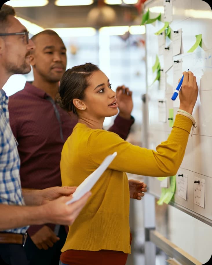 Three people collaborating on a whiteboard